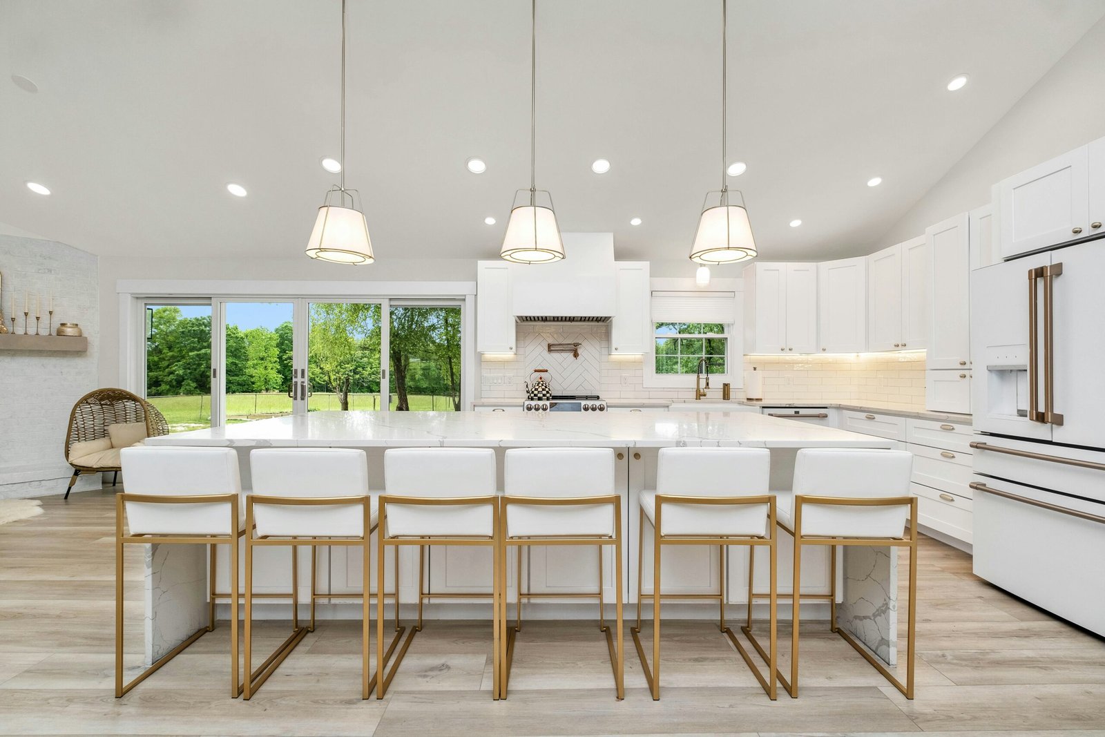 Bright kitchen with beautiful long quartz counter-top and 6 chairs with gold trim.