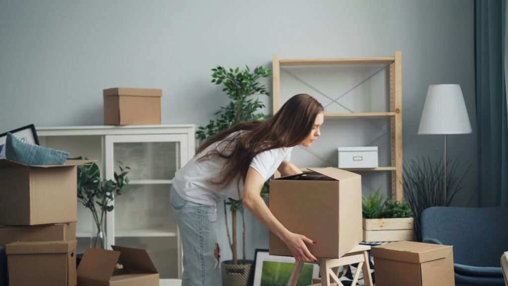 Woman placing moving boxes in a living room while preparing to sell her home — represents Selling a Home in Northern Kentucky and Cincinnati